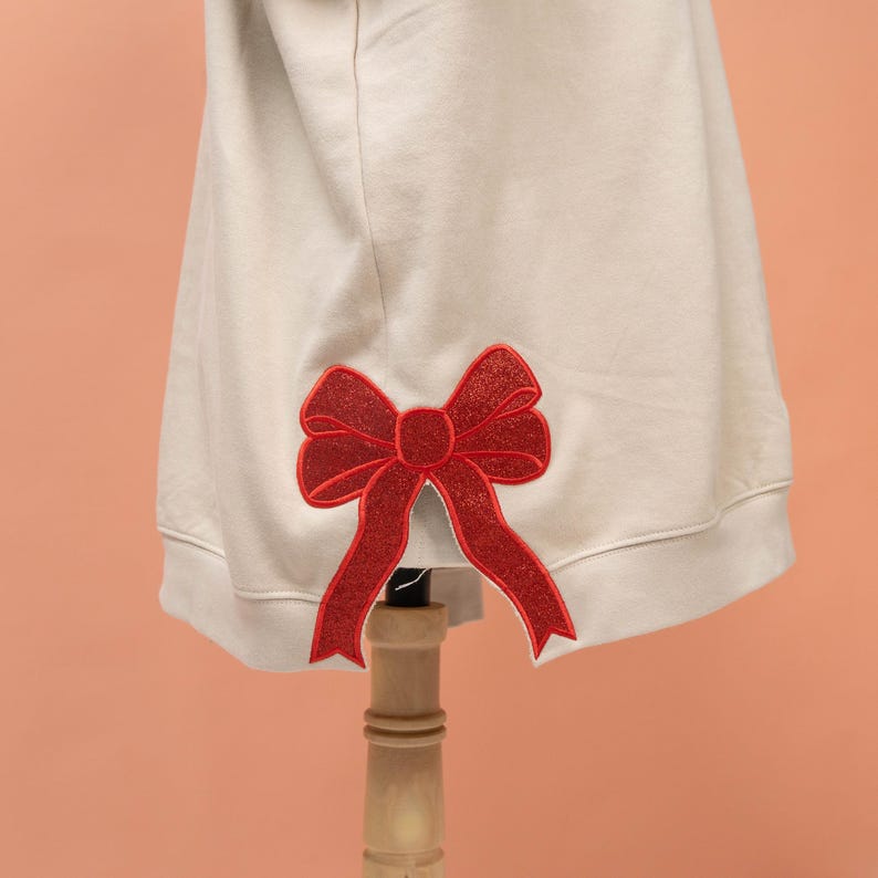 Glitter Gigi Est Claus Embroidered Side Bow Cut-Out Sweatshirt